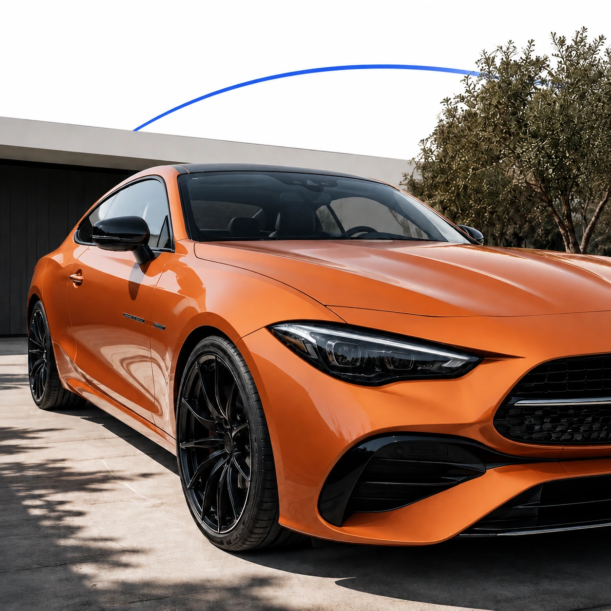 Orange coupe in a sunny driveway, showing its paint, front wheel and side window